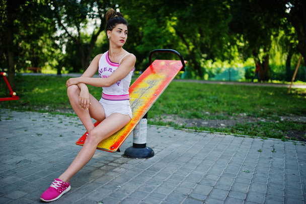 Sport girl wear on white shorts ans shirt doing exercises on sim - Photo, image