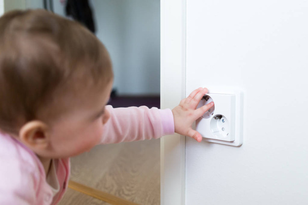 Small child touches an electrical outlet at home. Safety of children - Фото, зображення
