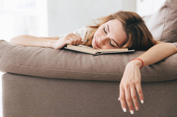 Tired relaxed woman sleep with book on sofa - Fotoğraf, Görsel