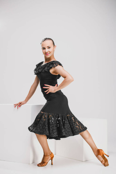 girl in black dress dancing in white studio - Valokuva, kuva
