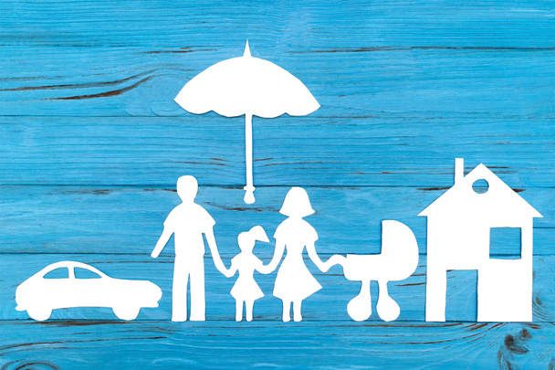Paper silhouette of family with baby carriage under umbrella - Photo, Image