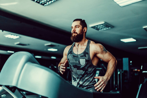 Muscle man running on treadmill. - Фото, зображення