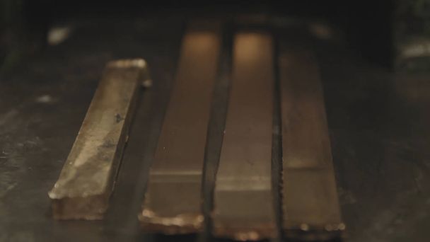 Hand-rolled gold bars. Factory worker processing roll of steel sheet. METAL INDUSTRY. Rolling mill machine for rolling steel sheet. Tilt shift effect - Zdjęcie, obraz
