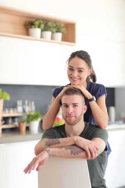 Beautiful young couple is having fun in kitchen at home - Fotoğraf, Görsel