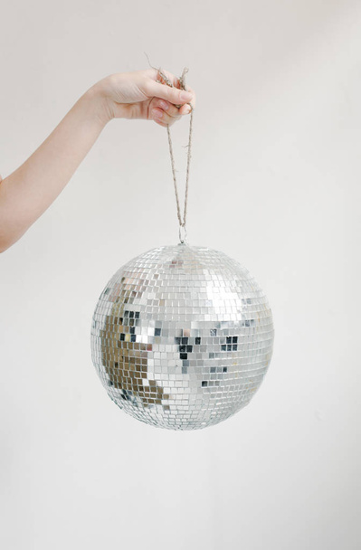 Hand holding disco ball on string  - Foto, Imagen