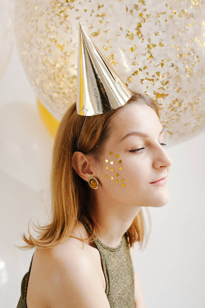 pensive young woman in celebratory cap - Zdjęcie, obraz