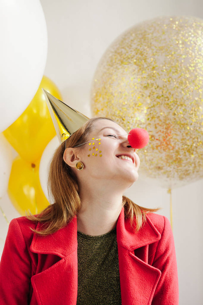 smiling woman with red clown nose  - 写真・画像