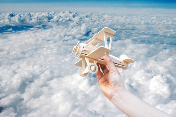 Lançamento manual de avião de madeira e céu azul em dia nublado
 - Foto, Imagem
