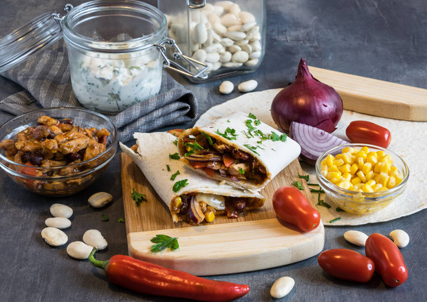 Tortilla pszenna z mieszaniną wieprzowiny, fasoli, czerwonej cebuli i kukurydzy - Zdjęcie, obraz
