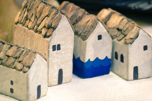 Miniaturhaus auf Tischplatte, Bausteine reihenweise angeordnet. - Foto, Bild