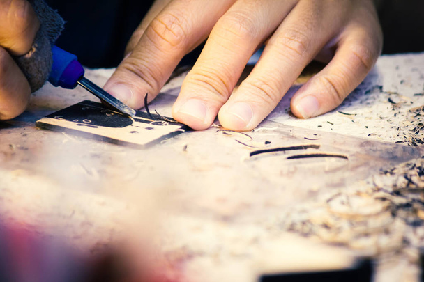 Hands Of Craftsman Carve With Engraving Tool On Table. - Photo, Image