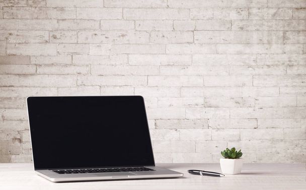 Business laptop with white brick wall - Foto, imagen
