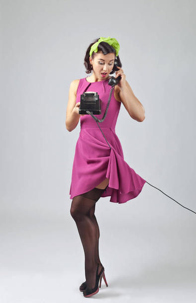 Όμορφη γυναίκα σε pin up στυλ με vintage τηλέφωνο. - Φωτογραφία, εικόνα