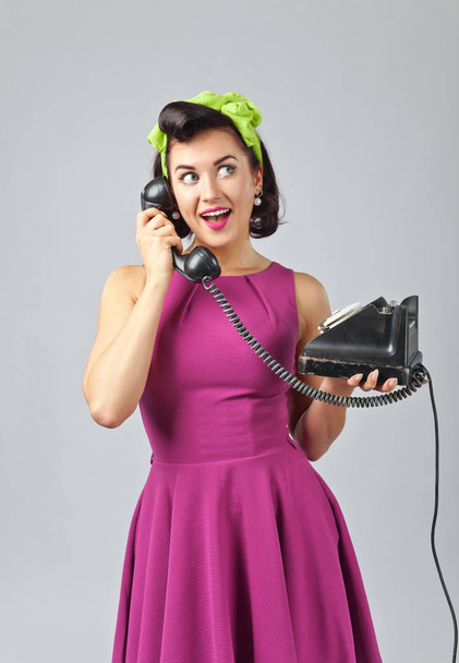 Beautiful woman in pin up style with vintage phone. - Фото, изображение