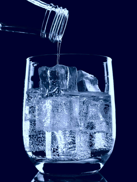 Бутылка содовой минеральной воды, разливающейся в стекло
 - Фото, изображение