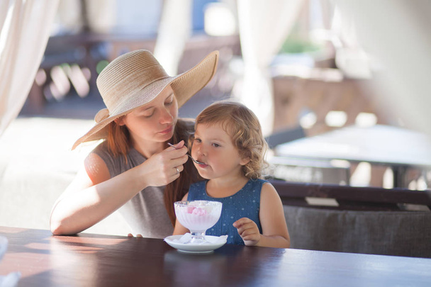 Mother and daughter eating ice cream at the restaurant - Foto, Imagen