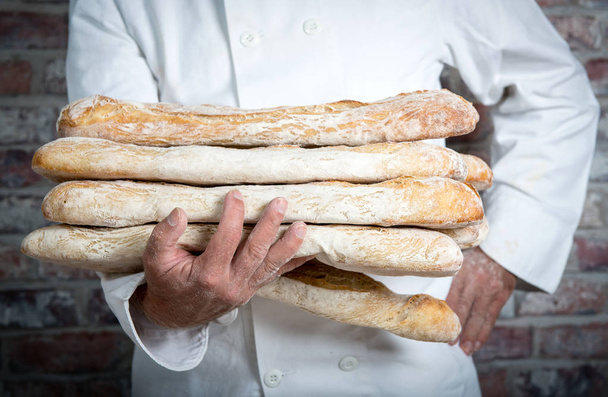 Baker drží tradiční chléb francouzské bagety - Fotografie, Obrázek
