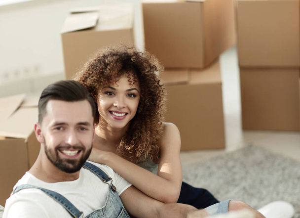 Young couple sitting on the floor in a new apartment - Photo, Image
