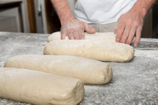 el panadero prepara la masa de pan
 - Foto, Imagen