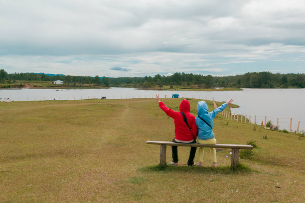 Dvojice sedící na židli při pohledu na jezero - Fotografie, Obrázek