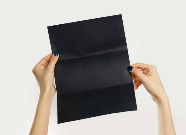 Frauenhände halten ein schwarzes Büchlein mit drei Blatt Papier in der Hand. Isol - Foto, Bild