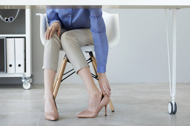 Nuori nainen kärsii jalka kipu virassa
 - Valokuva, kuva