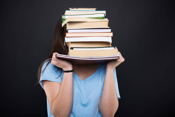 Молодая ученица прячется за школьными книгами
 - Фото, изображение