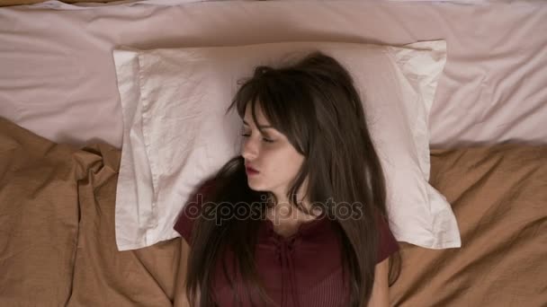 Attractive young woman laying in bed feeling bored - Filmagem, Vídeo