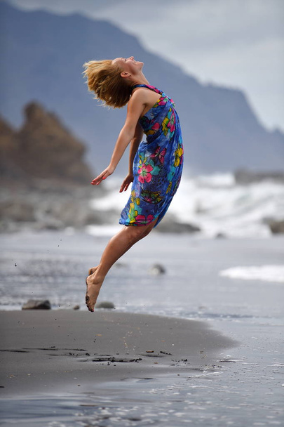 young woman jumping on the beach - Fotoğraf, Görsel