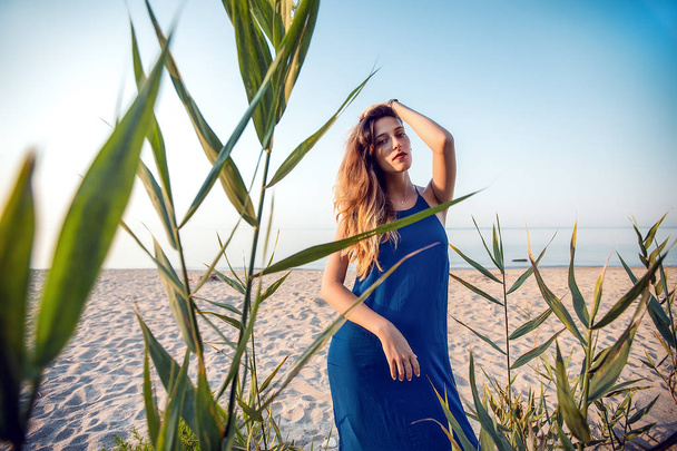 женщина позирует на песчаном пляже
 - Фото, изображение
