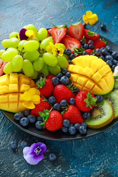 Piatto variopinto di frutta mista con mango, fragola, mirtillo, kiwi e uva verde. Cibo sano
 - Foto, immagini