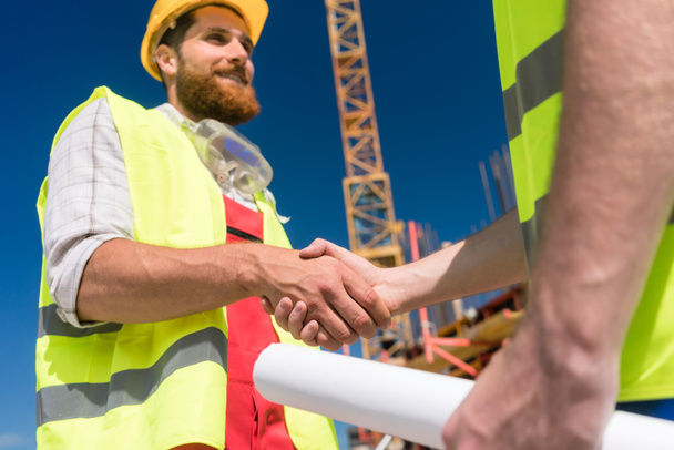 Trabalhador alegre apertando a mão de um arquiteto no início
 - Foto, Imagem