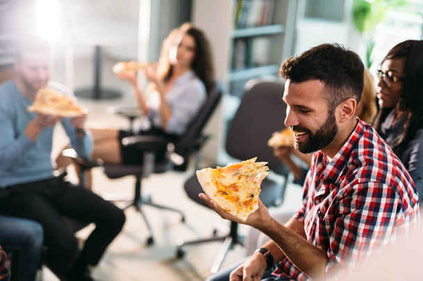 Software enginneers sharing pizza on break from work in their company - Фото, зображення