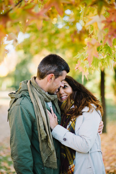Young couple of lovers embracing in autumn at city park - Foto, Imagem