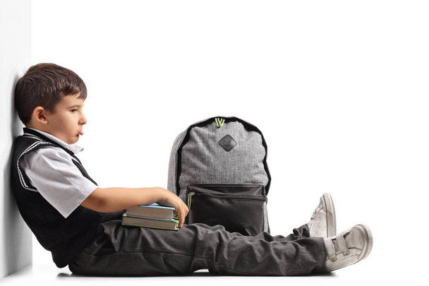 Sad schoolboy with a backpack and books - Foto, Bild