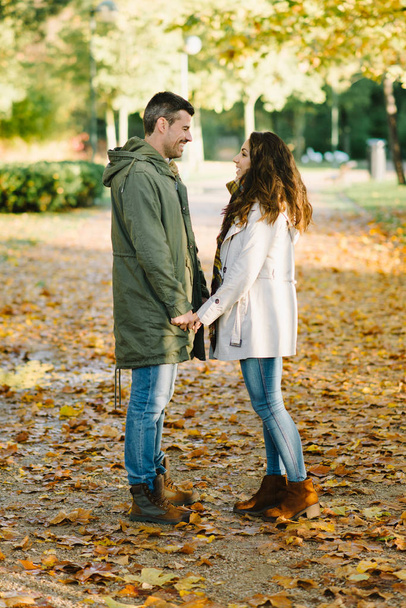 Young lovely couple flirting in autumn walk at the park - Photo, Image