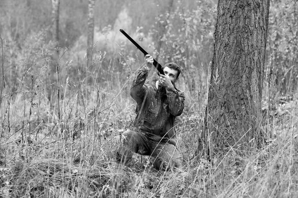 Muž v maskování a s loveckou puškou v lese na sp - Fotografie, Obrázek