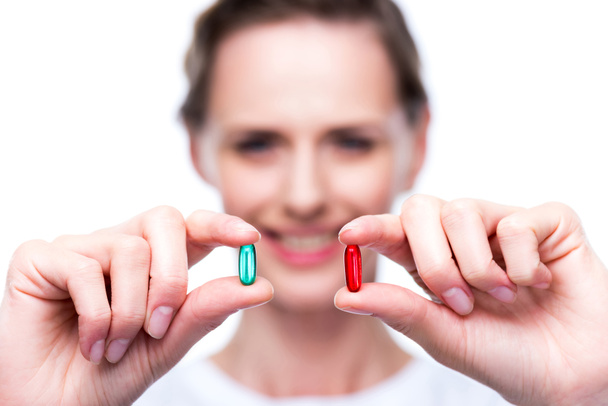 mulher com comprimidos vermelhos e azuis
 - Foto, Imagem