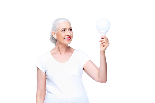 senior woman with light bulb - Fotoğraf, Görsel