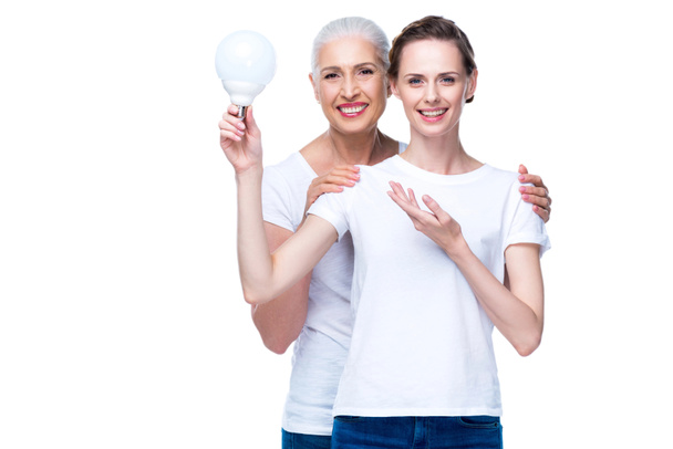 adult daughter and mother with light bulb - Foto, afbeelding