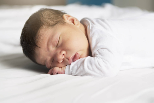 Baby sleeping on white sheet - Фото, изображение
