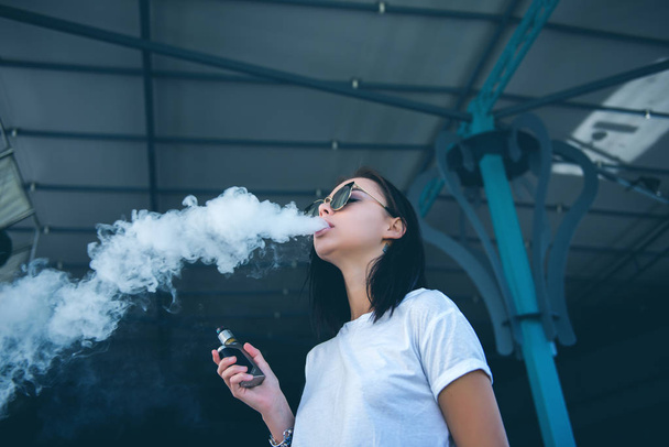 attractive girl in sunglasses vaping - Photo, image