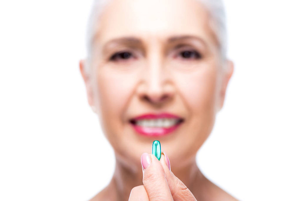 senior woman with pill - Фото, изображение