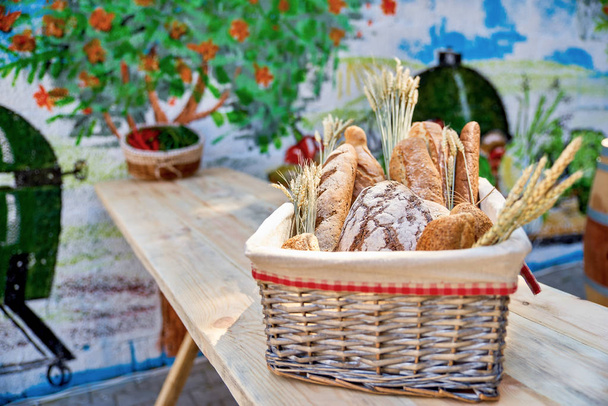 Bread basket outdoors on a wooden table in a street cafe, closeu - Photo, image