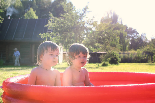 child splashing in the bath outdoors - Photo, Image