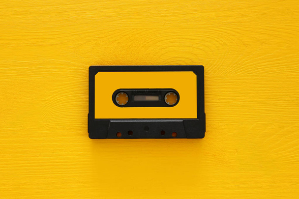 Retro cassette tape over yellow wooden table. top view. copy space - Фото, зображення