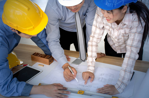 Engineering team is meeting, planning construction work, looking paper plans at construction site - Foto, Imagem