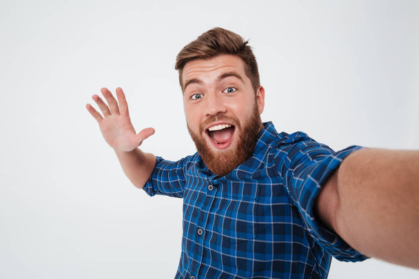 Happy bearded man in shirt making selfie and giving five - Foto, afbeelding