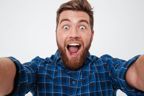 Крупним планом картинка Щасливий кричущий бородатий чоловік в картатій сорочці
 - Фото, зображення