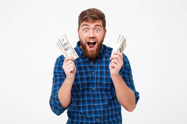 Happy screaming bearded man holding money in hands - Fotó, kép